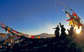 中国西藏 ，朝圣者将风马旗扔向甘登寺上方的空中为新年祈福