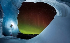 北极光当空闪耀，一名登山者攀爬阿萨巴斯卡冰川时