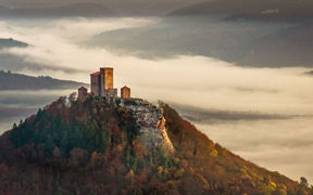 德国莱茵兰普法尔茨森林 ，秋日雾中清晨里的特里斐斯城堡