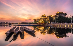 广角镜头下的厦门龙舟池，日落的光洒在传统龙舟上，中国 